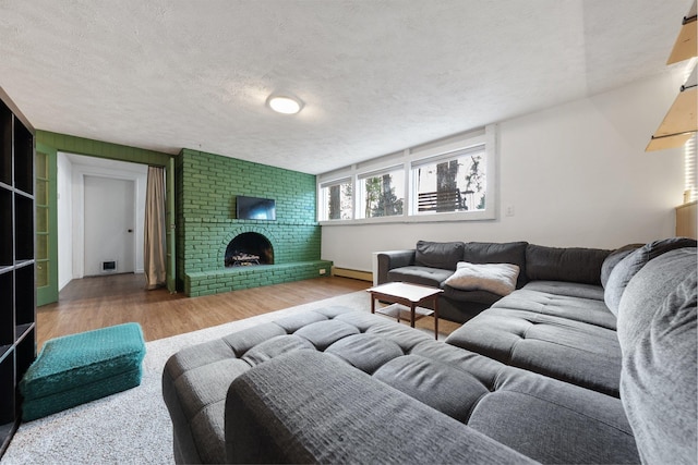 11010 E 28th Ave, Spokane, WA 99206 - living area with a textured ceiling, wood finished floors, a brick fireplace, a baseboard radiator, and baseboards