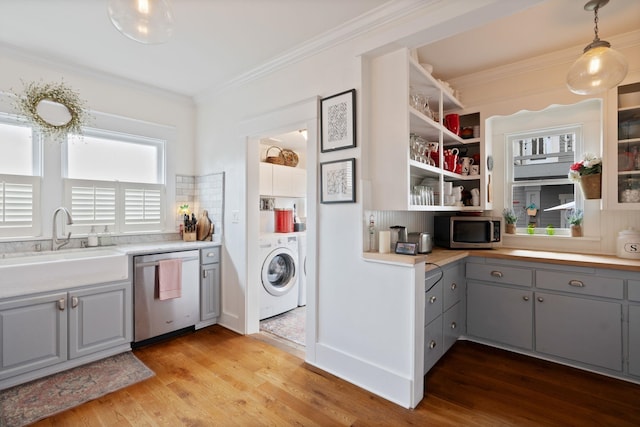 kitchen with stainless steel appliances, washer / clothes dryer, gray cabinetry, a sink, and light wood-style floors