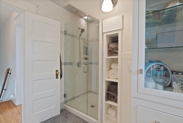 bathroom featuring a shower stall and wood finished floors