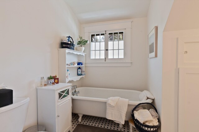 bathroom featuring a freestanding tub and toilet