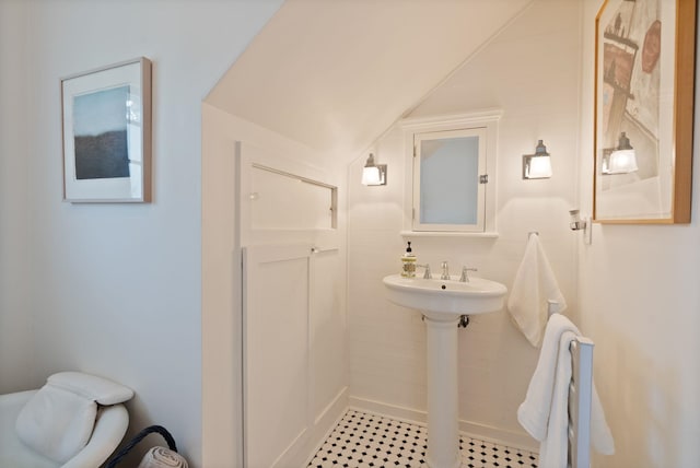 bathroom featuring lofted ceiling and a shower