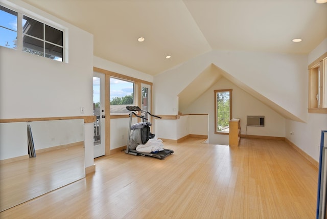 workout area featuring light wood finished floors, lofted ceiling, french doors, and an AC wall unit