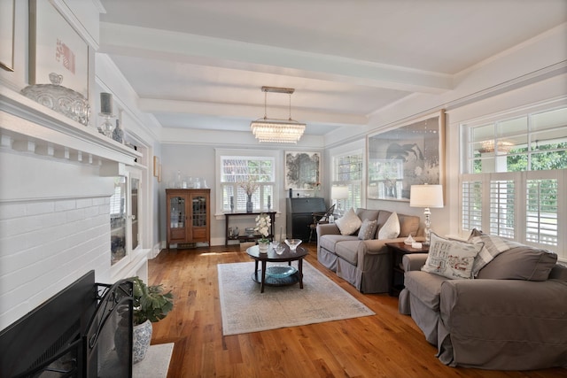 living area featuring beamed ceiling and light wood-style flooring