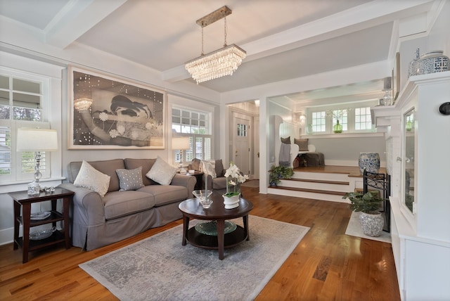 living room with wood finished floors, beamed ceiling, and a chandelier