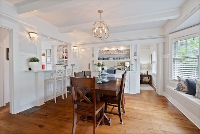 dining space featuring beam ceiling, a chandelier, and light wood-style floors
