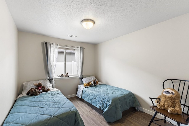 18924 E Fredrick Ave, Otis Orchards, WA 99027 - bedroom featuring wood finished floors, baseboards, and a textured ceiling