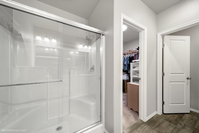 7919 W 55th Ave, Spokane, WA 99224 - bathroom featuring a stall shower, a walk in closet, and wood finished floors