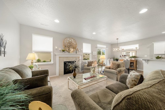7919 W 55th Ave, Spokane, WA 99224 - living room featuring a glass covered fireplace, light colored carpet, a textured ceiling, recessed lighting, and baseboards