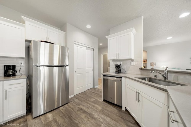 7919 W 55th Ave, Spokane, WA 99224 - kitchen featuring stainless steel appliances, a sink, recessed lighting, backsplash, and white cabinetry