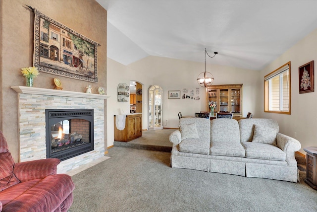 10610 N Iroquois Dr, Spokane, WA 99208 - living room featuring carpet flooring, vaulted ceiling, a chandelier, a stone fireplace, and arched walkways