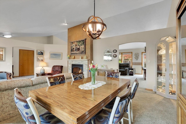 10610 N Iroquois Dr, Spokane, WA 99208 - dining area with light colored carpet, arched walkways, a fireplace, lofted ceiling, and a chandelier