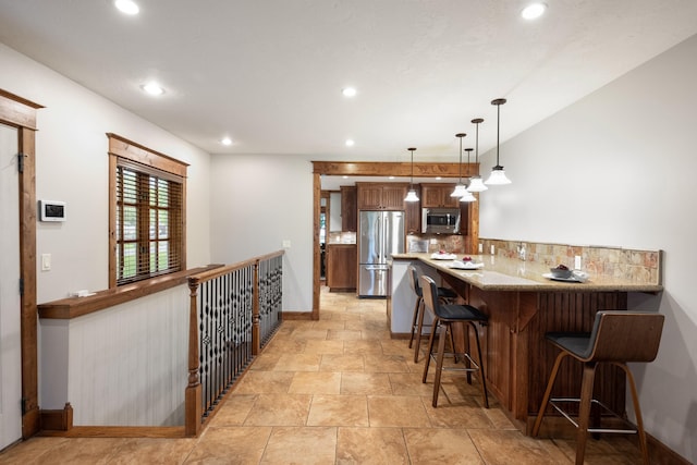 10204 N Wellen Ln, Spokane, WA 99218 - kitchen with stainless steel appliances, a breakfast bar, backsplash, recessed lighting, and baseboards