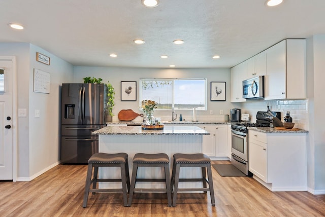 4521 E Fairview St, Spokane, WA 99217 - kitchen featuring stainless steel appliances, light stone countertops, a breakfast bar area, white cabinets, and recessed lighting
