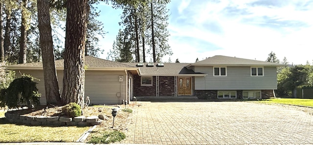 1425 W Parkwood Ct, Spokane, WA 99218 - tri-level home featuring decorative driveway, a front yard, and brick siding