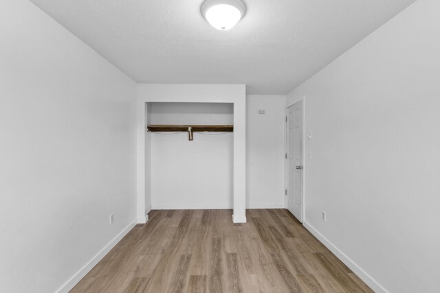 2362 Nicholson Rd, Elk, WA 99009 - unfurnished bedroom with wood finished floors, a closet, baseboards, and a textured ceiling