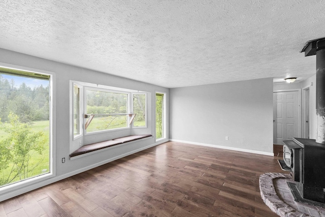 2362 Nicholson Rd, Elk, WA 99009 - unfurnished living room with a wood stove, a textured ceiling, baseboards, and wood finished floors