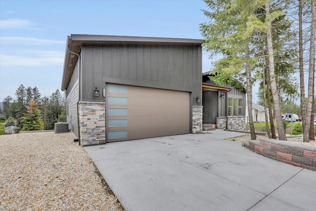 39980 Lake Summit Dr, Loon Lake, WA 99148 - view of front of home featuring stone siding, cooling unit, concrete driveway, and board and batten siding