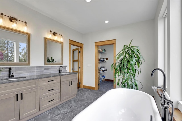 39980 Lake Summit Dr, Loon Lake, WA 99148 - bathroom featuring a freestanding bath, double vanity, tasteful backsplash, recessed lighting, and baseboards