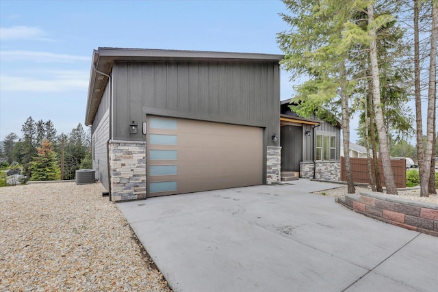 39980 Lake Summit Dr, Loon Lake, WA 99148 - view of front of home featuring stone siding, central AC, board and batten siding, and driveway