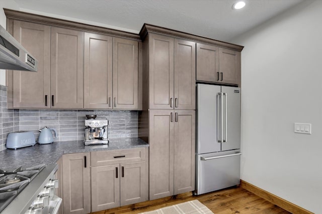 39980 Lake Summit Dr, Loon Lake, WA 99148 - kitchen with high end refrigerator, light wood-style flooring, range, decorative backsplash, and ventilation hood