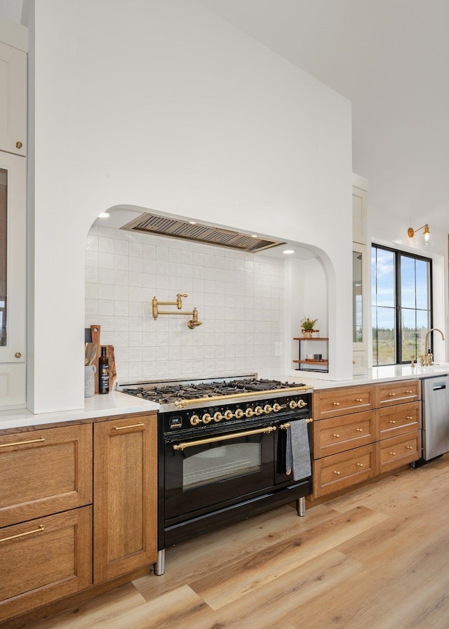 23114 W Mcfarlane Rd, Medical Lake, WA 99022 - kitchen with range with two ovens, brown cabinets, stainless steel dishwasher, and light wood-style floors