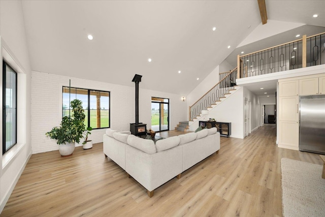 23114 W Mcfarlane Rd, Medical Lake, WA 99022 - living area featuring high vaulted ceiling, a wood stove, stairway, beamed ceiling, and light wood-type flooring