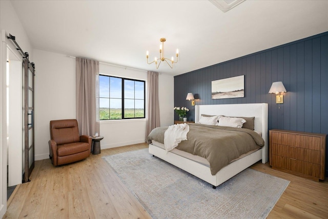 23114 W Mcfarlane Rd, Medical Lake, WA 99022 - bedroom featuring a barn door, a chandelier, light wood finished floors, and baseboards