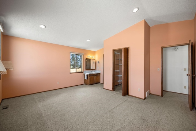 4796 W Gibson Dahl Rd, Clayton, WA 99110 - unfurnished living room featuring light colored carpet, baseboards, lofted ceiling, a textured ceiling, and recessed lighting