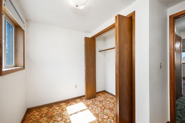 4796 W Gibson Dahl Rd, Clayton, WA 99110 - unfurnished bedroom with a textured ceiling, baseboards, and a closet