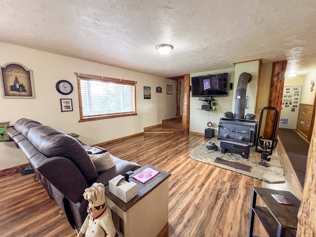 2010 Clemons Rd, Rice, WA 99167 - living area featuring a textured ceiling, a wood stove, wood finished floors, and baseboards