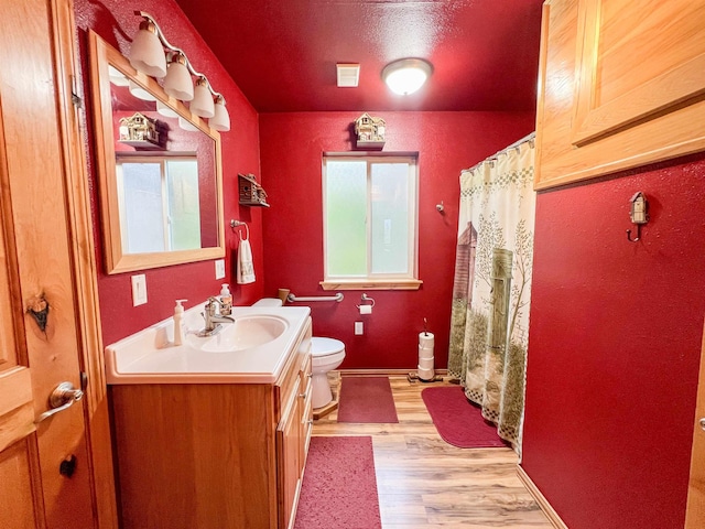 2010 Clemons Rd, Rice, WA 99167 - bathroom featuring vanity, toilet, wood finished floors, baseboards, and curtained shower
