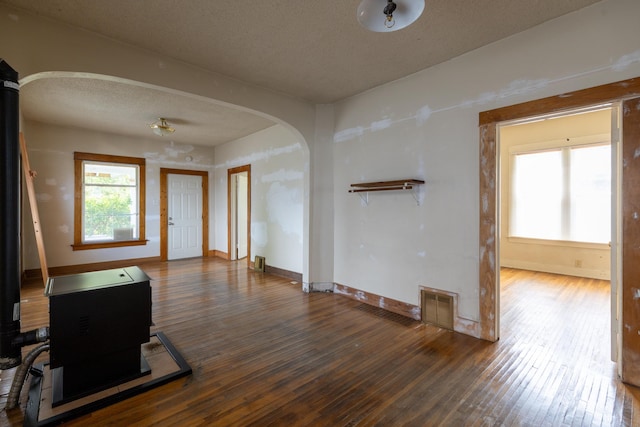 608 S Hatch St, Spokane, WA 99202 - entryway featuring arched walkways, wood-type flooring, baseboards, a textured ceiling, and a wood stove