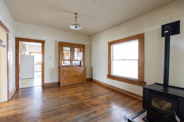 608 S Hatch St, Spokane, WA 99202 - interior space with a wood stove, wood-type flooring, a textured ceiling, and baseboards