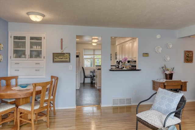 12820 E Sinto Ave, Spokane Valley, WA 99216 - dining room with a textured ceiling, light wood finished floors, and baseboards