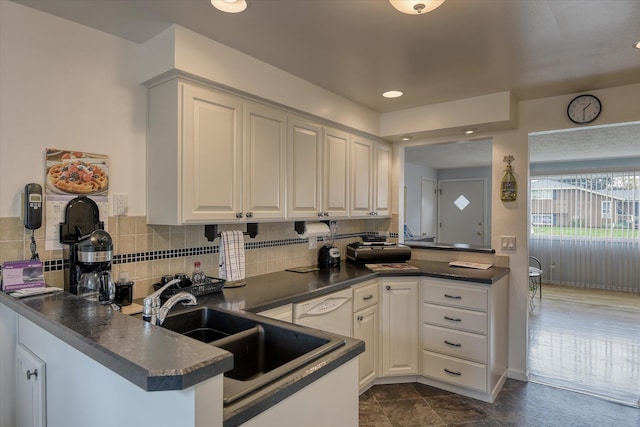 12820 E Sinto Ave, Spokane Valley, WA 99216 - kitchen featuring a peninsula, dark countertops, decorative backsplash, white cabinetry, and recessed lighting