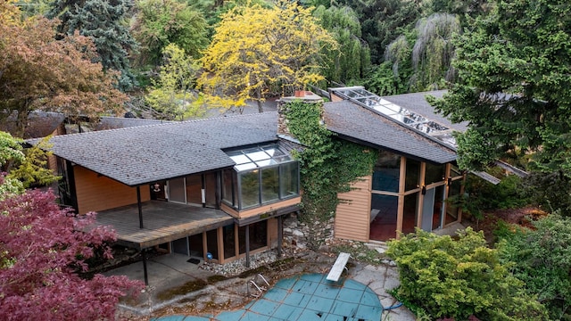 12515 E Apache Pass Rd, Spokane, WA 99206 - rear view of property featuring a patio area, a sunroom, and a shingled roof