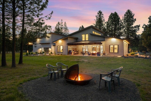 220 E Meadowlane Rd, Spokane, WA 99224 - rear view of property featuring an outdoor fire pit, a yard, a patio area, and board and batten siding
