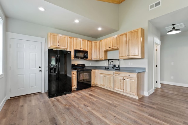 344 W Deer Park Milan Rd, Deer Park, WA 99006 - kitchen with black appliances, light brown cabinetry, light wood-type flooring, dark countertops, and recessed lighting