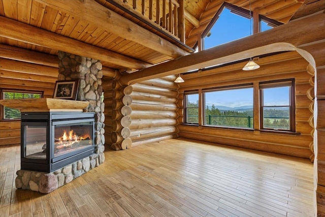 18109 N Harvard Ln, Newman Lake, WA 99025 - unfurnished living room featuring a stone fireplace, hardwood / wood-style floors, wooden ceiling with exposed beams, and log walls
