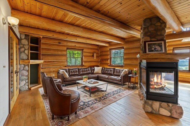 18109 N Harvard Ln, Newman Lake, WA 99025 - living room featuring a multi sided fireplace, hardwood / wood-style flooring, rustic walls, and wood ceiling with exposed beams