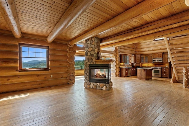 18109 N Harvard Ln, Newman Lake, WA 99025 - unfurnished living room featuring a stone fireplace, rustic walls, wood ceiling with exposed beams, and light wood-type flooring