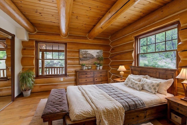 18109 N Harvard Ln, Newman Lake, WA 99025 - bedroom with log walls, multiple windows, wood finished floors, and wooden ceiling with exposed beams