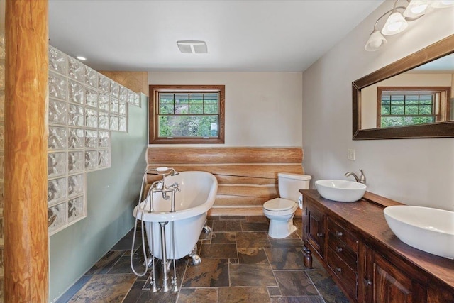 18109 N Harvard Ln, Newman Lake, WA 99025 - bathroom with stone tile floors, a freestanding tub, double vanity, and toilet