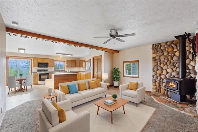 18109 N Harvard Ln, Newman Lake, WA 99025 - living area featuring a wood stove, ceiling fan, a textured ceiling, and light colored carpet