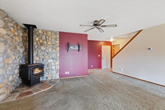 18109 N Harvard Ln, Newman Lake, WA 99025 - unfurnished living room featuring ceiling fan, carpet flooring, a wood stove, a textured ceiling, and baseboards