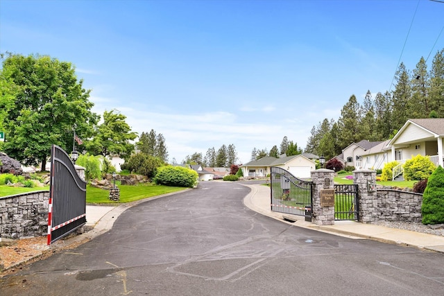 3515 W Excell Ln, Spokane, WA 99208 - view of asphalt road featuring a residential view, curbs, a gate, sidewalks, and a gated entry