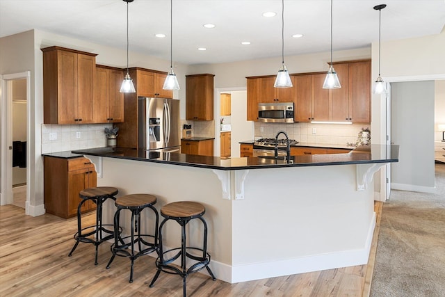 3515 W Excell Ln, Spokane, WA 99208 - kitchen featuring appliances with stainless steel finishes, brown cabinetry, backsplash, dark countertops, and recessed lighting