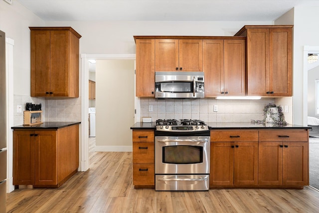 3515 W Excell Ln, Spokane, WA 99208 - kitchen featuring stainless steel appliances, dark countertops, brown cabinetry, and light wood finished floors