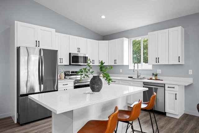 11911 N Main St, Mead, WA 99021 - kitchen featuring appliances with stainless steel finishes, a sink, a kitchen bar, dark wood finished floors, and vaulted ceiling