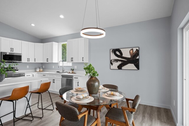 11911 N Main St, Mead, WA 99021 - kitchen with stainless steel appliances, a sink, light countertops, light wood finished floors, and lofted ceiling